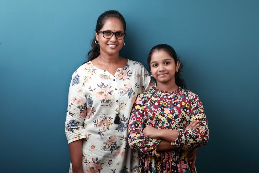 Mom helping teenage child with college application paperwork at desk